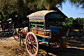 Inwa, Myanmar - tourists ride on a horse-drawn carriage. Riding on a horse cart is the easiest way to get around Inwa's narrow and dusty road to explore scatterred attractions. 